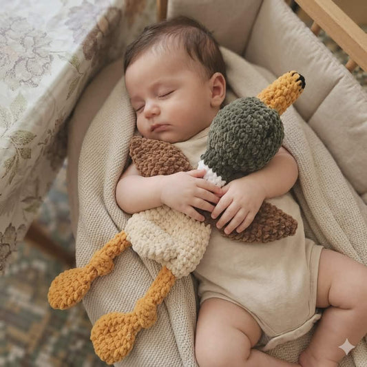 bébé endormi avec son doudou canard au crochet en fil doux chenille